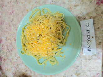 Шаг 12: Положите в тарелку макароны, сверху добавьте мелко натертый сыр.
