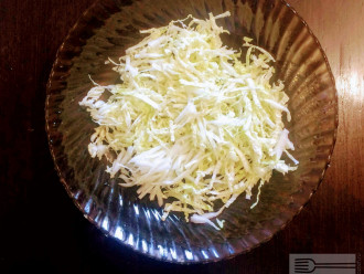Шаг 3: Пекинскую капусту мелко нарежьте и высыпьте в глубокую тарелку.