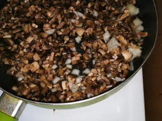 Шаг 5: Выложите грибы и лук в сковороду, добавьте 30 миллилитров воды. И готовьте 15 минут под крышкой.