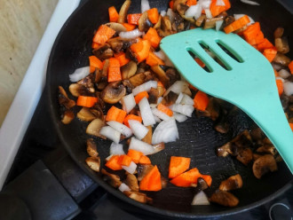 Шаг 4: Добавьте нарезанный лук и морковь. Жарьте еще 5 минут.