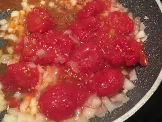 Шаг 3: Лук и чеснок очистите и нарежьте кубиками. Разогрейте масло, обжарьте в нем лук и чеснок, затем добавьте томаты.