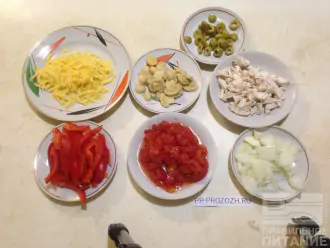 Шаг 4: Пока тесто в духовке, нарежьте помидоры, лук, перец, грибы, оливки, мясо. Натрите на терке сыр.