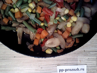Шаг 3: Пока варится крупа, потушите на сковороде без масла замороженные грибы и овощи. Тушите до тех пор, пока не испарится вся жидкость.