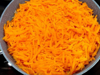 Шаг 4: Морковь почистите, помойте, натрите на крупной терке, добавьте в сковородку к луку и протушите до готовности.