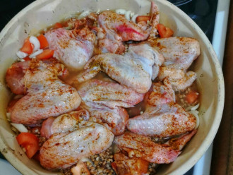 Шаг 4: Сверху вылейте гречку с водой. И выложите курицу.

