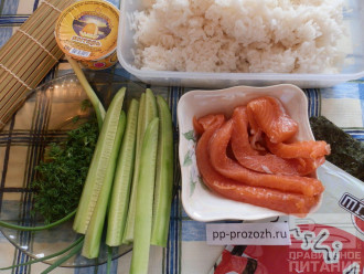 Шаг 1: Подготовьте ингредиенты: вареный рис для суши, водоросли нори, огурец, форель или семгу слабосоленую, плавленый сыр, укроп, зеленый лук. Также вам понадобится коврик для приготовления суши и роллов.
Коврик застелите пищевой пленкой.