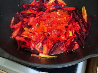 Шаг 5: Добавьте нарезанный мелко чеснок и томатный соус. Тщательно перемешайте. Оставьте тушить минут 7.
