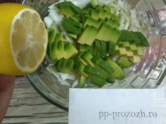 Шаг 4: Насыпьте в салатник капусту, авокадо и полейте лимонным соком. Добавьте немного цедры лимона.