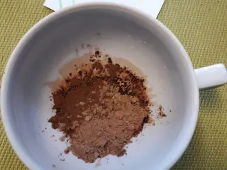Шаг 2: Всыпьте 1,5 чайных ложки порошка какао и 1 чайную ложку кэроба в чашку.