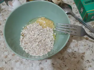 Шаг 3: В глубокую тарелку добавьте яйцо и овсяные хлопья.