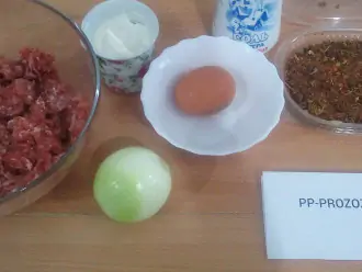 Шаг 1: Подготовьте ингредиенты: говяжий фарш, яйцо, лук, нежирную сметану, соль, специи.
