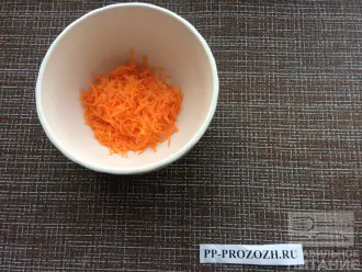 Шаг 2: Натрите морковь на мелкой терке. Выложите в миску.