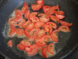 Шаг 8: На разогретую сковороду с маслом выложите нарезанные помидоры.