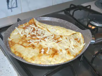 Шаг 5: Высыпьте оставшуюся половину сыра на овсяноблин и аккуратно, с помощью лопатки, скрутите.