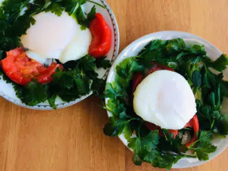 Шаг 6: Переложите яйцо на тарелку и украсьте помидором и зеленью. 