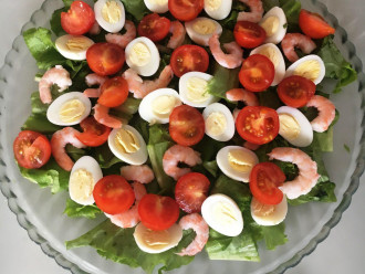 Шаг 7: Теперь выложите на листья салата яйца, помидоры и креветки.