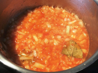 Шаг 3: В кастрюле разведите водой томатную пасту до консистенции густой сметаны. Добавьте оливковое масло, нарезанный лук, лавровый лист, посолите по вкусу и поставьте тушиться до тех пор, пока томат не уварится, а лук не станет совершенно мягким.