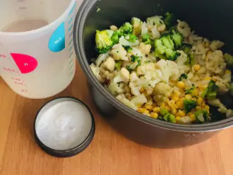 Шаг 7: Переложите картофель, морковь, кукурузу и лук в чашу мультиварки. Залейте все ингредиенты водой, посолите и перемешайте. 