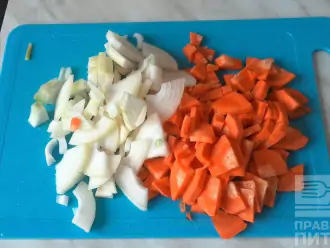 Шаг 3: Морковь и лук нарежьте небольшими кусочками. Когда вода с курицей закипит, добавьте овощи и пусть все варится до готовности курицы.