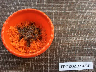 Шаг 2: Натрите морковь на мелкой тёрке. Смешайте с приправой по-корейски и оливковым маслом и оставьте на полчаса.
