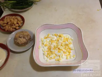Шаг 2: Яйца отварите и нарежьте кубиками. Выложите в салатницу.