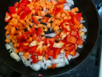 Шаг 4: К луку добавьте нарезанную на квадратики морковь и перец. Обжаривайте до выкипания воды.