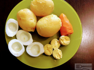 Шаг 2: Отварите до готовности картофель, морковь и яйца. Очистите от кожуры. Яйца разрежьте пополам и отделите белок от желтка. Картофель и морковь потрите на крупной терке или порежьте очень мелко кубиками. 