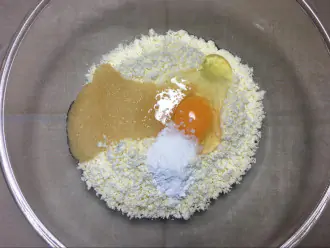 Шаг 3: Добавьте к творогу яйцо, мёд и разрыхлитель.
