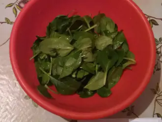Шаг 2: Выложите шпинатный салат. Крупные листья можно разрезать на несколько частей.