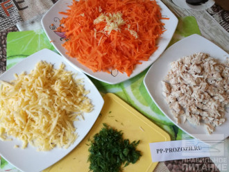 Шаг 2: Сыр и морковь натрите на крупной терке, чеснок натрите на мелкой терке или пропустите через пресс и смешайте с морковью. Куриную грудку и зелень нарежьте.
