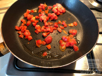 Шаг 2: На разогретую сковороду с чайной ложкой оливкового масла выложите замороженные помидоры (или нарежьте кусочками свежие). Обжарьте 3 минуты на среднем огне.