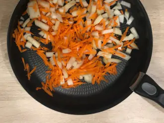 Шаг 4: Лук и морковь выложите на сковороду и готовьте 5-7 минут на слабом огне.