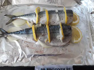 Шаг 4: Переложите рыбу на противень, застеленный фольгой. Сделайте на рыбе разрезы до хребта и положите в них лимон и лук.