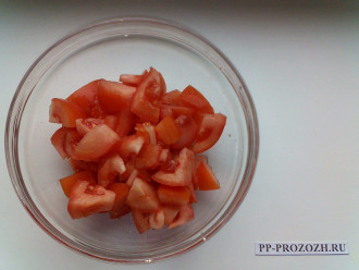 Шаг 2: Нарежьте помидор крупными кубиками и отправьте в салатницу. Отложите 1 столовую ложку помидора для сервировочной заготовки.