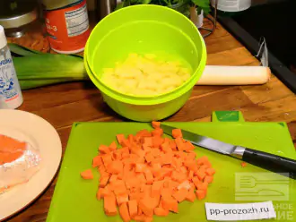 Шаг 2: Поставьте кастрюлю с водой на плиту. Пока вода будет закипать, нарежьте картофель и морковь любимым способом. Я режу кубиками. Бросьте в кипящую воду. 