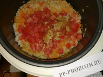 Шаг 7: В тушеные овощи с рисом добавьте помидоры, чеснок, соль и специи. Перемешайте. Мультиварку выключите.
