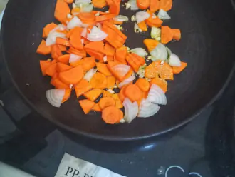 Шаг 4: Пока варится булгур, нарежьте лук и морковь. Обжарьте 5 минут на сухой а/п сковороде.