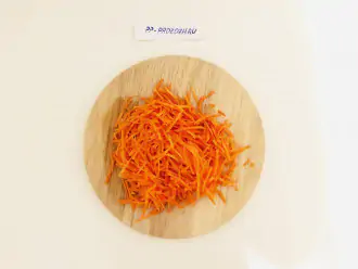 Шаг 3: Натрите на терке для корейской моркови (или на обычной крупной терке) морковь.