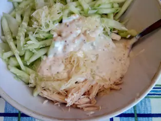 Шаг 4: Смешайте сметану с горчицей, солью, чесноком, добавьте куриное филе и огурцы, перемешайте все в глубокой посуде.