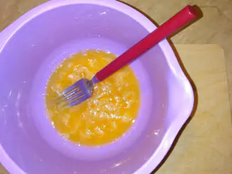 Шаг 2: Разбейте два яйца в миску, добавьте соль. Взбейте вилкой до легкой пены.