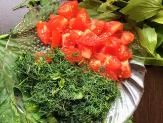 Шаг 7: Нарежьте зелень и помидоры, добавьте к овощам, перемешайте и еще тушите 5 минут. 