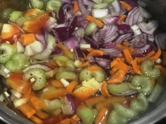 Шаг 5: Поместите в кастрюлю сельдерей, сладкий перец, помидоры, морковь и лук. Залейте водой, чтобы она полностью покрывала все овощи. Варите на слабом огне около 30 минут.