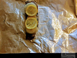 Шаг 4: Посолите и поперчите по вкусу. На рыбку уложите порезанный лук и лимон с обеих сторон. Можно также и внутрь.