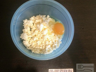 Шаг 2: В глубокую миску насыпьте творог и вбейте яйцо.