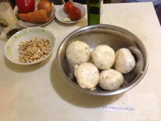 Шаг 3: Шляпки грибов замаринуйте в смеси из 2 ложек оливкового масла, одного зубчика чеснока, измельченного через пресс, и щепотки соли.