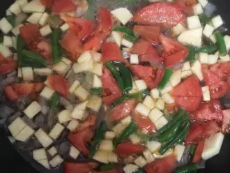 Шаг 4: Добавьте нарезанные овощи и стручковую фасоль к луку и готовьте еще 5 минут.