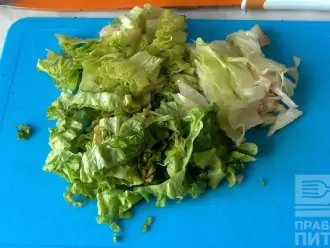 Шаг 4: Листья салата помойте и высушите. Нарежьте небольшими кусочками и уложите в салатник. Поверх листьев салата выложите сыр.