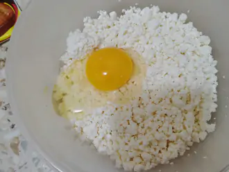 Шаг 2: В миску выложите творог и яйцо.