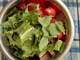 Шаг 4: Соедините говядину, помидоры и листья салата в одной посуде. Полейте маслом и посыпьте кунжутом, все перемешайте.