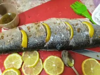 Шаг 8: Натрите рыбу с 2-х сторон соусом и вставьте в надрезы лимон.